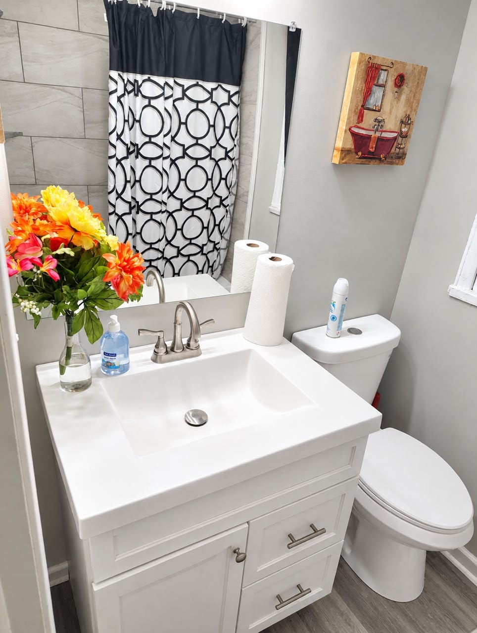 Clean bathroom with white vanity and colorful flowers